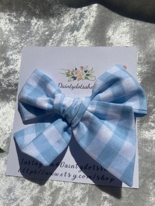 Blue fabric gingham bow, ideal for a girls birthday present. You can either choose a clip or bobble for your bow.